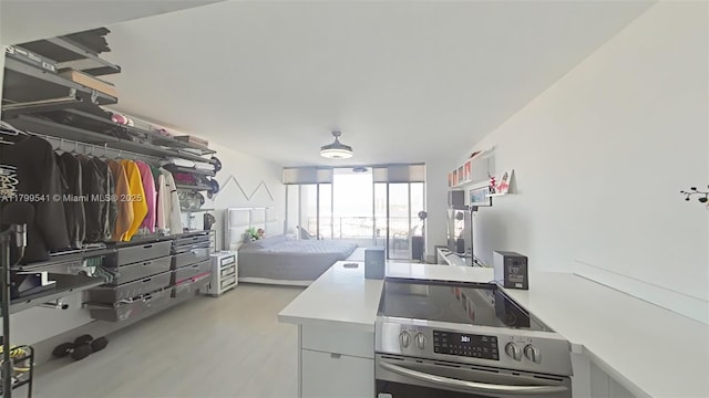 555 NE 15th St Unit 508, Miami, FL 33132 - kitchen with electric range, wood finished floors, open floor plan, and light countertops