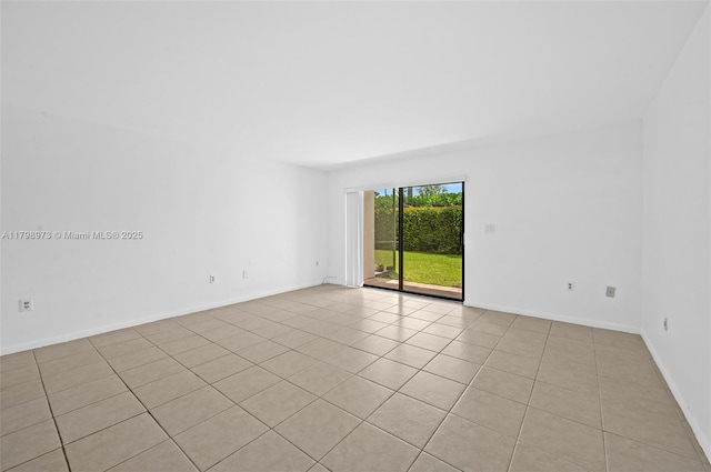 spare room featuring light tile patterned floors and baseboards