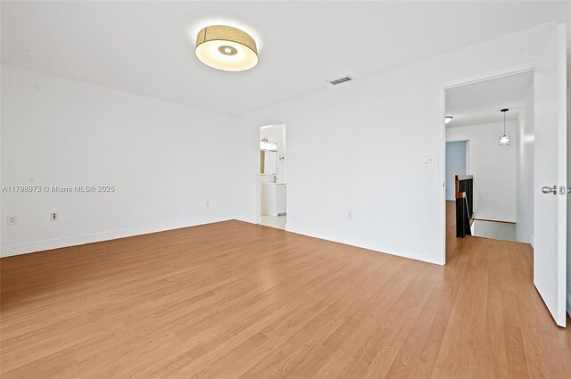 spare room with light wood-type flooring and baseboards