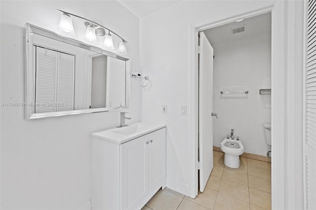 bathroom featuring a bidet, vanity, tile patterned floors, a closet, and baseboards
