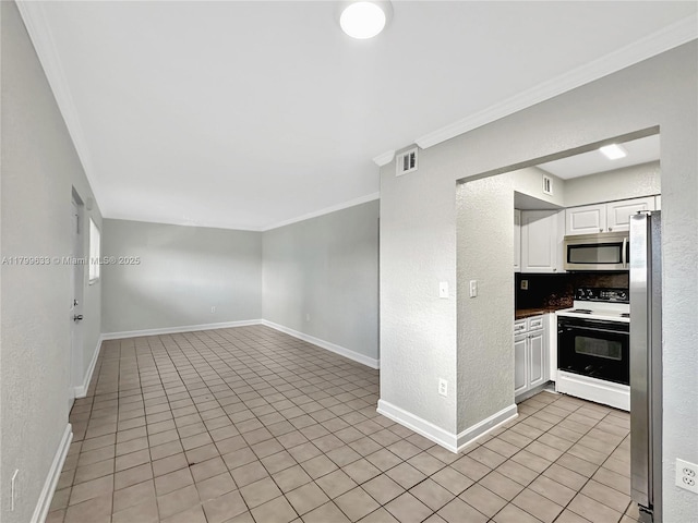 empty room with crown molding, baseboards, light tile patterned floors, and a textured wall