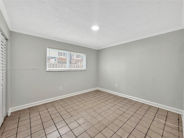 empty room featuring a textured ceiling, baseboards, and ornamental molding