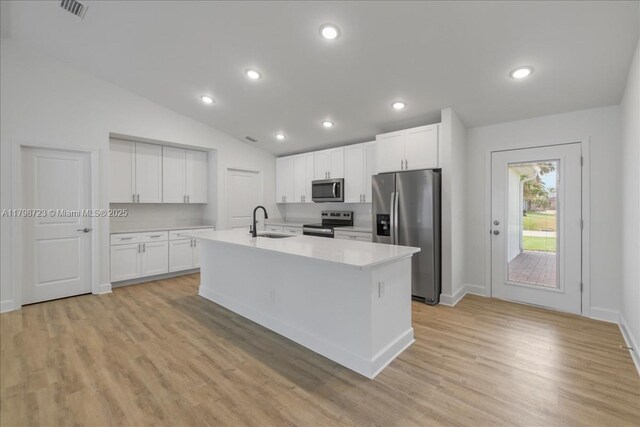 2048 NW 3rd Ter, Cape Coral, FL 33993 - kitchen with appliances with stainless steel finishes, light countertops, white cabinetry, lofted ceiling, and a kitchen island with sink