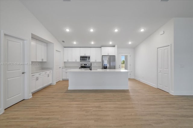 2048 NW 3rd Ter, Cape Coral, FL 33993 - kitchen with appliances with stainless steel finishes, vaulted ceiling, light countertops, light wood-type flooring, and an island with sink