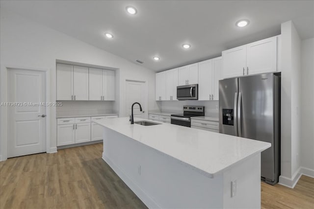 2048 NW 3rd Ter, Cape Coral, FL 33993 - kitchen with stainless steel appliances, a sink, vaulted ceiling, white cabinetry, and light wood finished floors