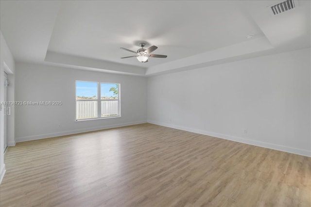 2048 NW 3rd Ter, Cape Coral, FL 33993 - spare room featuring a tray ceiling, light wood-style floors, ceiling fan, and baseboards