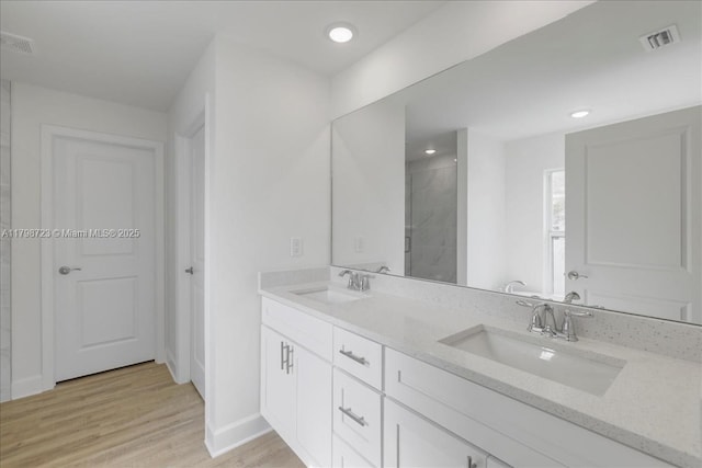 2048 NW 3rd Ter, Cape Coral, FL 33993 - full bath featuring wood finished floors, tiled shower, baseboards, double vanity, and recessed lighting