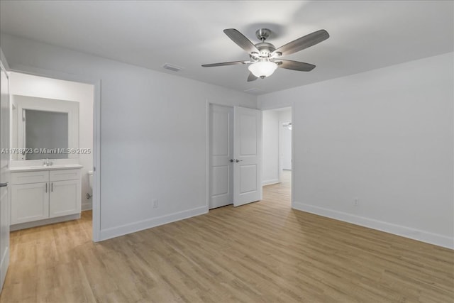 2048 NW 3rd Ter, Cape Coral, FL 33993 - unfurnished bedroom featuring baseboards, light wood finished floors, ensuite bathroom, and a sink
