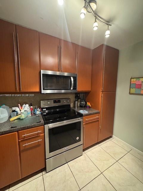 10047 Winding Lake Rd Unit 203, Sunrise, FL 33351 - kitchen with appliances with stainless steel finishes, dark countertops, light tile patterned floors, and track lighting