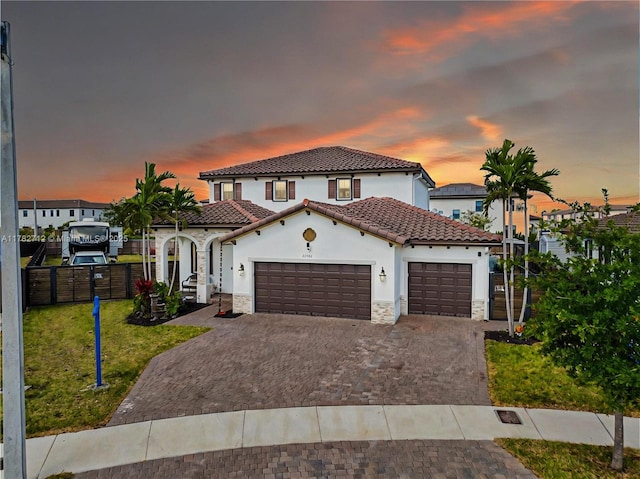 22986 SW 128th Pl, Miami, FL 33170 - mediterranean / spanish home with stucco siding, a garage, a tiled roof, stone siding, and decorative driveway
