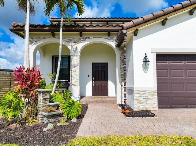 22986 SW 128th Pl, Miami, FL 33170 - property entrance with stucco siding, a garage, stone siding, and a tile roof