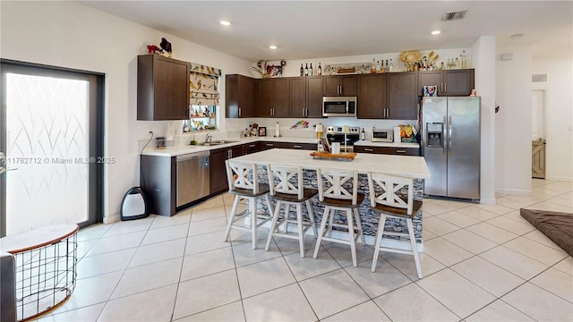 22986 SW 128th Pl, Miami, FL 33170 - kitchen featuring stainless steel appliances, dark brown cabinets, light countertops, a sink, and light tile patterned floors