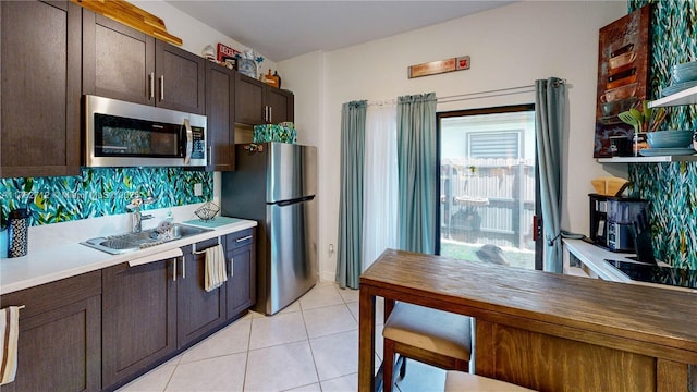 22986 SW 128th Pl, Miami, FL 33170 - kitchen with stainless steel appliances, decorative backsplash, dark brown cabinets, light tile patterned flooring, and a sink