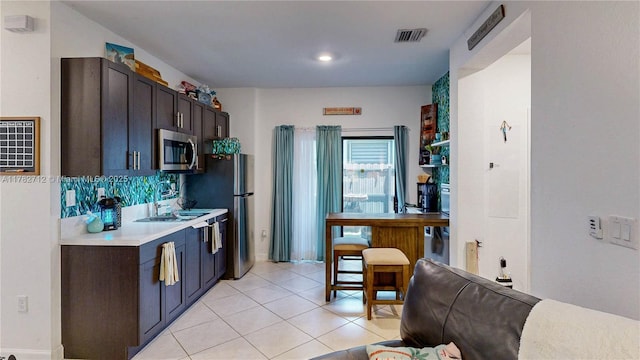 22986 SW 128th Pl, Miami, FL 33170 - kitchen with stainless steel appliances, light countertops, light tile patterned flooring, and dark brown cabinets