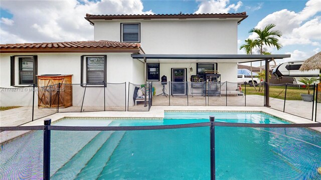 22986 SW 128th Pl, Miami, FL 33170 - rear view of property featuring a patio area, stucco siding, fence, and an outdoor pool