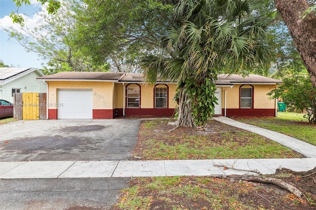 8101 NW 44th Ct, Lauderhill, FL 33351 - ranch-style house with an attached garage, stucco siding, asphalt driveway, and brick siding