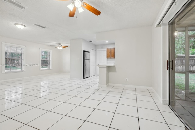 8101 NW 44th Ct, Lauderhill, FL 33351 - spare room with a ceiling fan, a textured ceiling, healthy amount of natural light, and light tile patterned floors