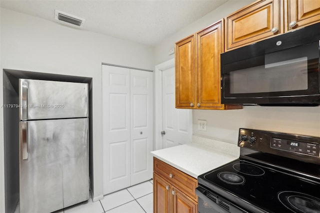 8101 NW 44th Ct, Lauderhill, FL 33351 - kitchen with black appliances, light tile patterned flooring, brown cabinetry, and light countertops