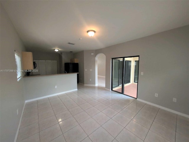 22664 SW 109th Path, Miami, FL 33170 - unfurnished living room with light tile patterned floors, arched walkways, and baseboards