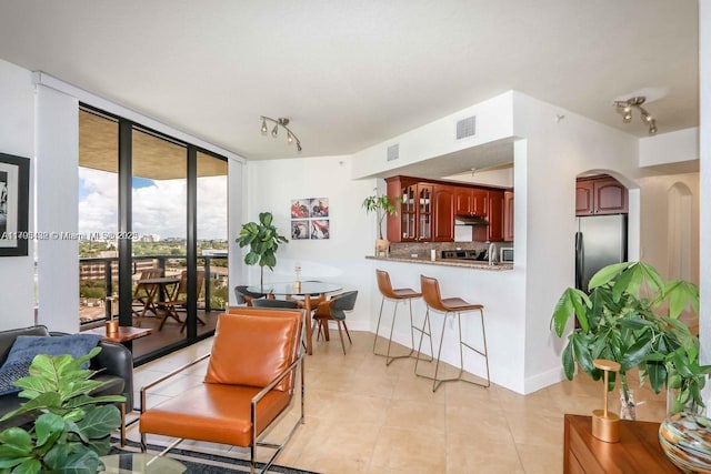 2301 SW 27th Ave Unit 1100, Miami, FL 33145 - living room with light tile patterned floors, arched walkways, floor to ceiling windows, and baseboards