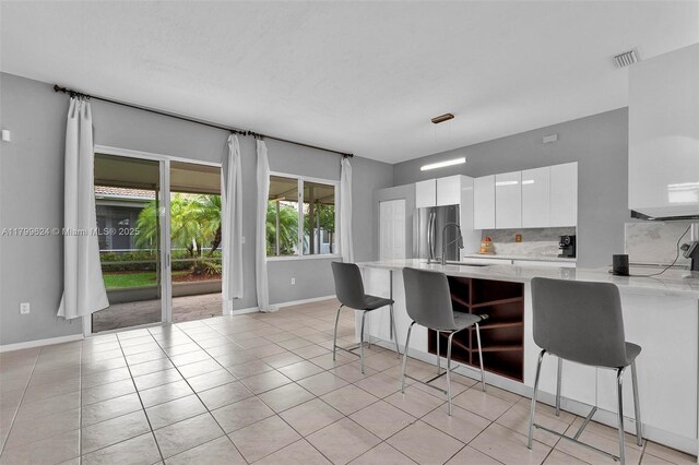 2625 SE 5th Ct, Homestead, FL 33033 - kitchen with a kitchen breakfast bar, white cabinets, baseboards, and freestanding refrigerator