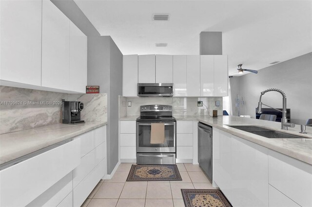 2625 SE 5th Ct, Homestead, FL 33033 - kitchen featuring appliances with stainless steel finishes, a sink, modern cabinets, and backsplash