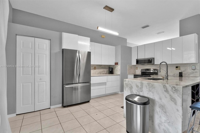 2625 SE 5th Ct, Homestead, FL 33033 - kitchen featuring stainless steel appliances, a sink, a kitchen breakfast bar, a peninsula, and tasteful backsplash