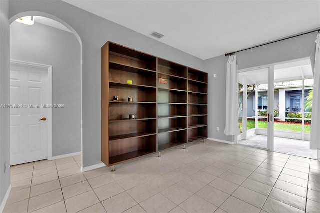 2625 SE 5th Ct, Homestead, FL 33033 - unfurnished room with light tile patterned floors, arched walkways, and baseboards