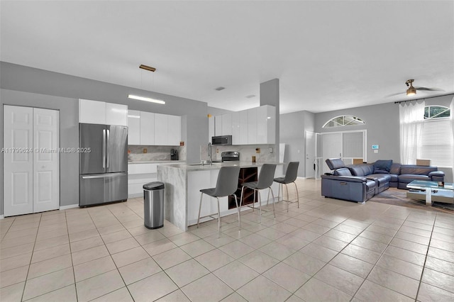 2625 SE 5th Ct, Homestead, FL 33033 - kitchen featuring stainless steel appliances, light countertops, open floor plan, a kitchen bar, and modern cabinets