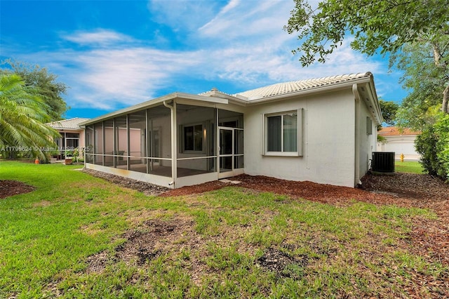 2625 SE 5th Ct, Homestead, FL 33033 - back of property with central AC unit, a lawn, a sunroom, stucco siding, and a tile roof