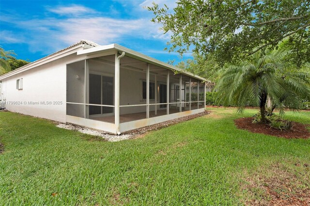 2625 SE 5th Ct, Homestead, FL 33033 - back of property with a sunroom, a lawn, a tiled roof, and stucco siding