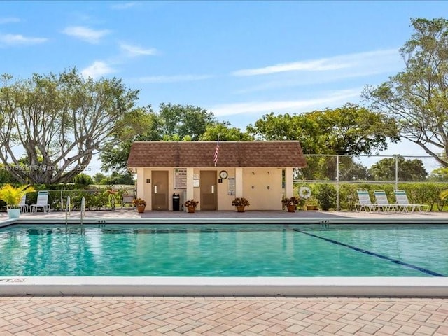 community pool featuring fence and a patio area