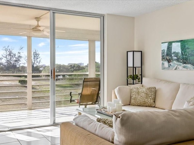 living area featuring ceiling fan, tile patterned flooring, floor to ceiling windows, and a textured ceiling