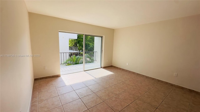 unfurnished room with tile patterned floors and baseboards