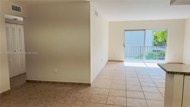 unfurnished room with light tile patterned floors and baseboards