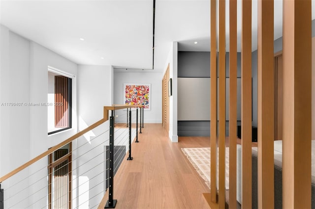 corridor featuring an upstairs landing, light wood finished floors, recessed lighting, and baseboards