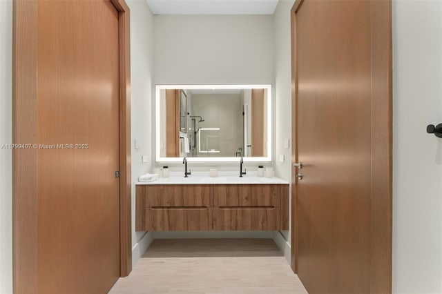 full bathroom featuring double vanity and wood finished floors