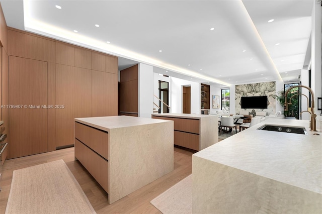 kitchen with modern cabinets, a center island, light wood finished floors, and recessed lighting