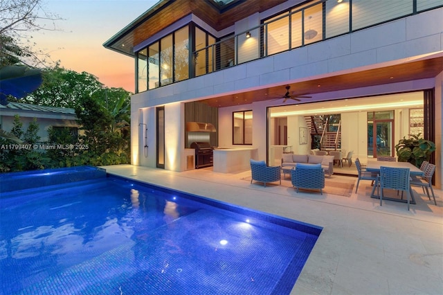 rear view of house with a patio, a ceiling fan, a balcony, and an outdoor living space