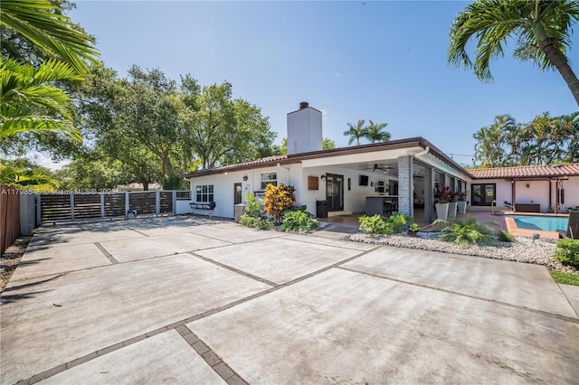 17514 SW 82nd Ct, Palmetto Bay, FL 33157 - back of house with a ceiling fan, a chimney, stucco siding, and a patio area
