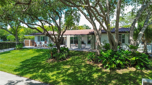 back of house featuring a tile roof, stucco siding, and a patio