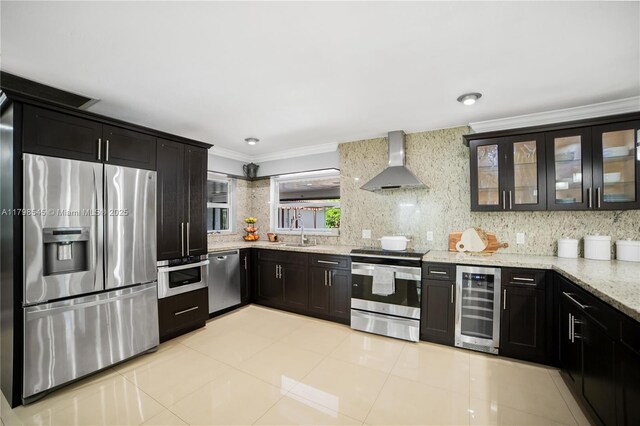 17514 SW 82nd Ct, Palmetto Bay, FL 33157 - kitchen with wine cooler, stainless steel appliances, wall chimney range hood, crown molding, and light stone countertops