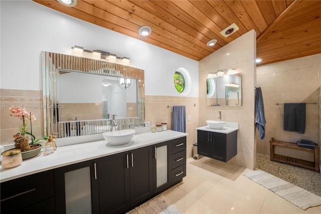 full bath featuring tile walls, tile patterned floors, wooden ceiling, two vanities, and lofted ceiling