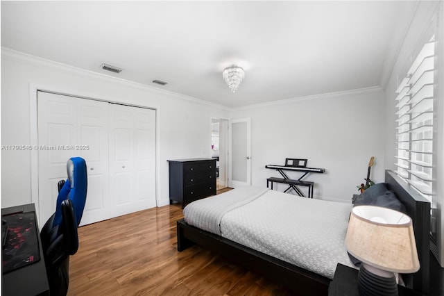 bedroom featuring ornamental molding, wood finished floors, and a closet