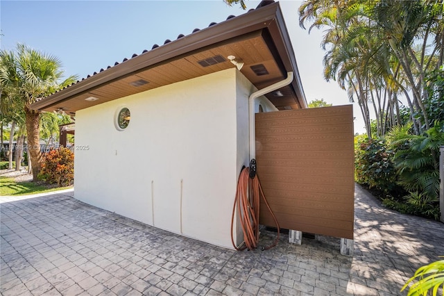 view of home's exterior with stucco siding and a patio area