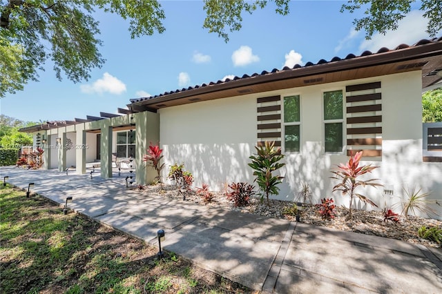 17514 SW 82nd Ct, Palmetto Bay, FL 33157 - view of side of property featuring a patio, a pergola, and stucco siding