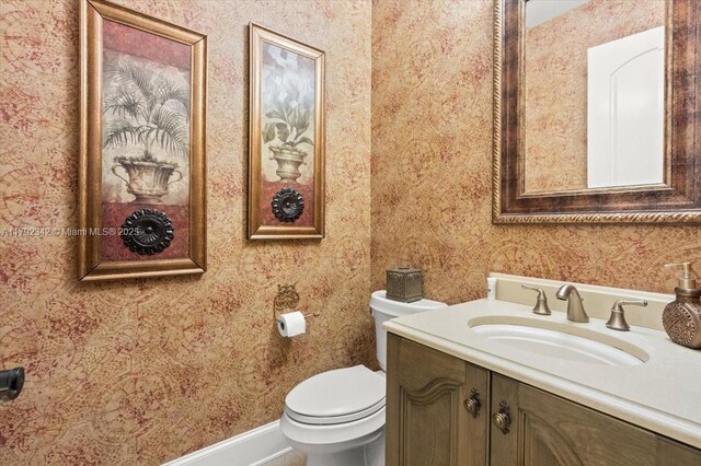 12 Tidewater Dr, Ormond Beach, FL 32174 - half bathroom with wallpapered walls, toilet, and vanity