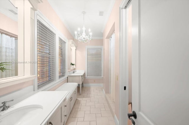 12 Tidewater Dr, Ormond Beach, FL 32174 - full bath with a chandelier, two vanities, baseboards, and crown molding