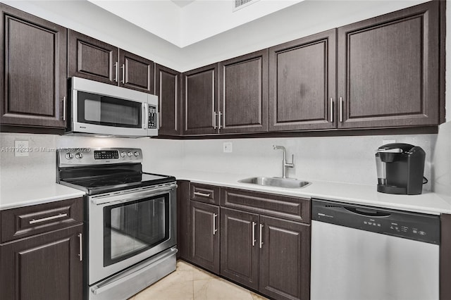 3400 NE 192nd St Unit Ph11, Aventura, FL 33180 - kitchen featuring appliances with stainless steel finishes, a sink, light marble finish floors, light countertops, and dark brown cabinets