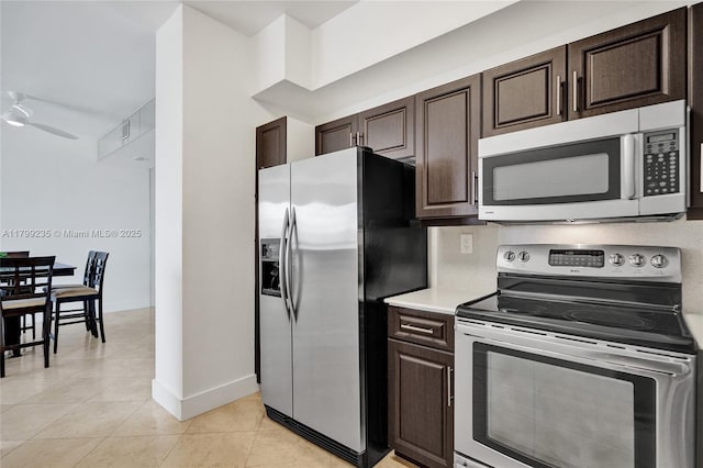 3400 NE 192nd St Unit Ph11, Aventura, FL 33180 - kitchen with stainless steel appliances, dark brown cabinetry, light countertops, baseboards, and light tile patterned flooring